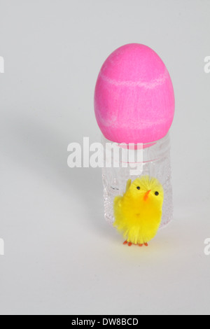 Oeufs colorés dans un récipient en verre, décorée pour Pâques. Banque D'Images