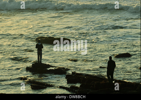 Durban, Afrique du Sud, silhouette, deux hommes debout sur des rochers en surf, pêche, tôt le matin, plage d'Umhlanga Rocks, paysage, personnage, l'atmosphère Banque D'Images