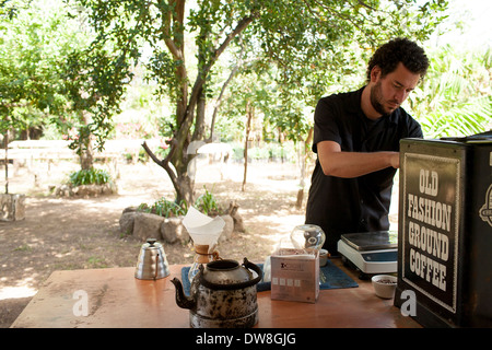 D'un poids et de broyage des grains de café fraîchement torréfié à préparer une tasse à l'aide d'une cafetière Chemex en El Salvador Juayua Banque D'Images