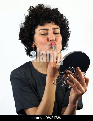 Woman putting on lipstick Banque D'Images