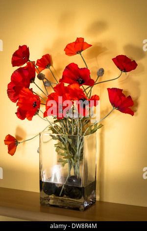 Coquelicots rouges artificielles dans un vase de verre à l'intérieur Banque D'Images