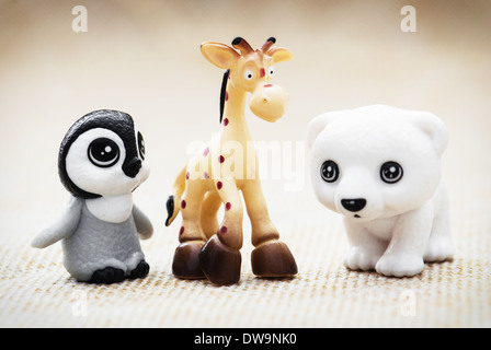 Trois figurines jouet en plastique. Penguin, la girafe et l'ours blanc. Banque D'Images