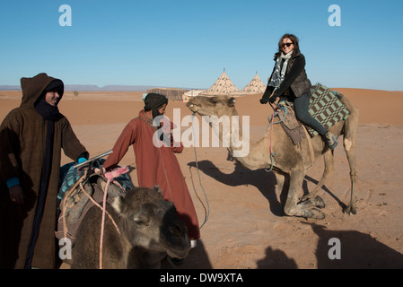 Les gens avec des chameaux dans un désert, Erg Chigaga Luxury Camp dans le désert, désert du Sahara, Maroc, Souss-Massa-Draa Banque D'Images