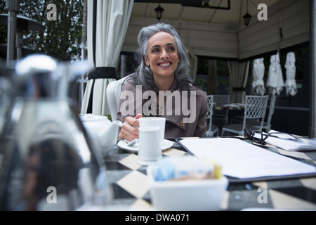 Young woman having coffee break sur porche de luxe Banque D'Images