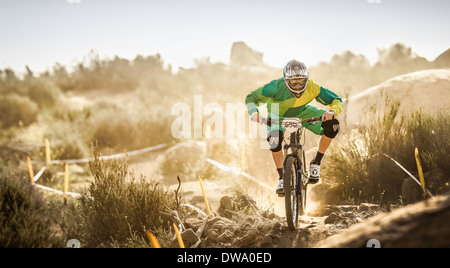 Vélo de montagne mâle course sur piste poussiéreuse, Fontana, California, USA Banque D'Images