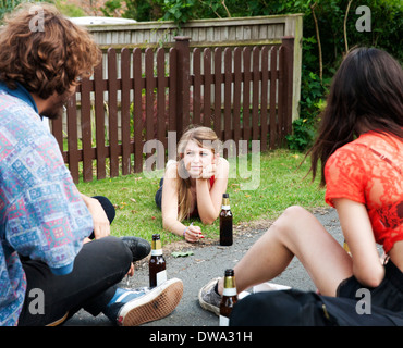 Friends sitting in garden boire de la bière Banque D'Images