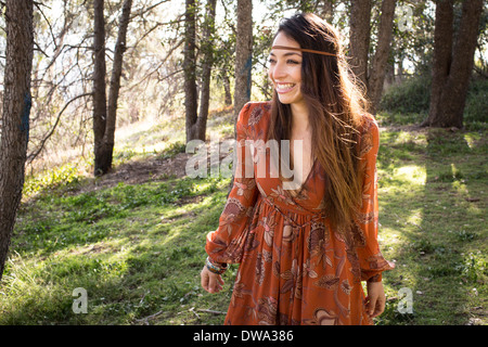 Portrait of young woman wearing dress en forêt, smiling Banque D'Images