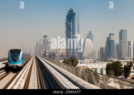 Un train sur le métro de Dubaï avec des gratte-ciel sur l'horizon, y compris la tour Burj Khalifa, DUBAÏ, ÉMIRATS ARABES UNIS, Moyen Orient Banque D'Images