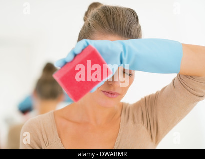 Femme au foyer pendant le nettoyage fatigué Banque D'Images