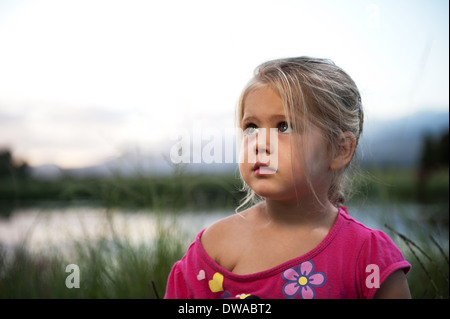 Cute girl en plein air pendant le coucher du soleil. Banque D'Images