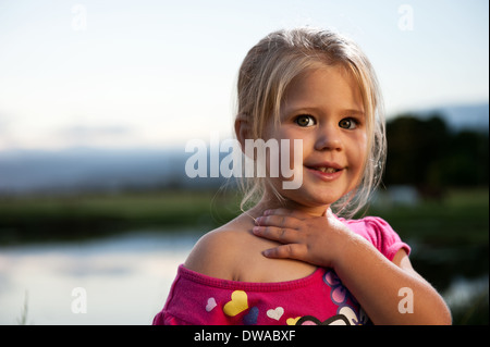 Cute girl en plein air pendant le coucher du soleil. Banque D'Images