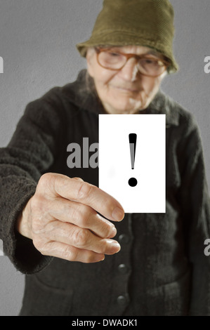 Femme âgée en tenant la carte avec des imprimés d'exclamation. Selective focus sur la carte et les doigts. Banque D'Images