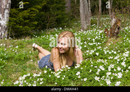 Très jolie jeune femme sur une prairie avec des fleurs Banque D'Images