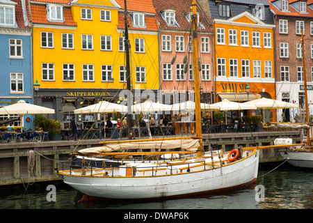 Bâtiments historiques peints dans des couleurs vives avec des cafés et bars Nyhavn à Copenhague en ligne Banque D'Images