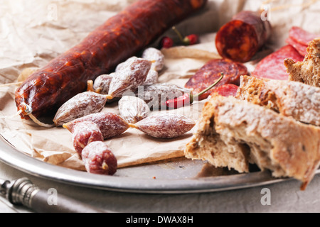 Ensemble de salami saucisses servis avec du pain frais et Red Hot Chili Peppers sur plateau vintage Banque D'Images