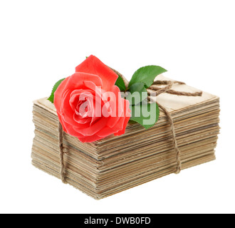 Pile d'anciennes lettres d'amour et de cartes postales avec des fleurs rose rouge isolé sur fond blanc. Photo sentimental nostalgique Banque D'Images