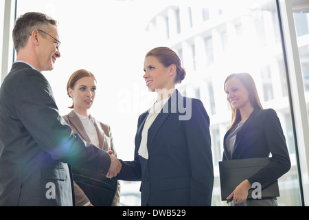 Confident business people shaking hands in office Banque D'Images