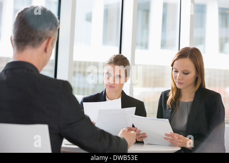 Business people discussing paperwork in office cafeteria Banque D'Images