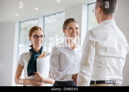 Happy business people shaking hands in office Banque D'Images