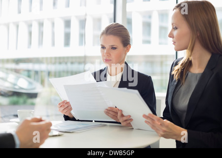 Businesswomen discussing documents sur in office cafeteria Banque D'Images