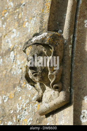 Pierre sculptée tête figure sur la fenêtre surround. Église Sainte-Marie, Beverston, Gloucestershire Banque D'Images