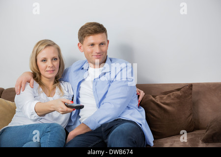 Couple watching television on sofa Banque D'Images