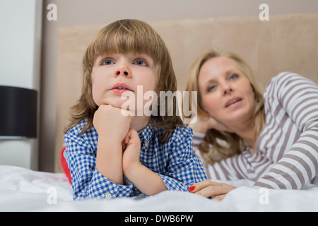 Garçon attentionné avec mère au lit Banque D'Images