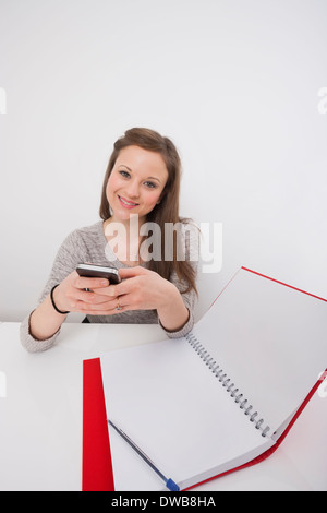 Portrait of businesswoman using cell phone in office Banque D'Images