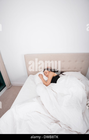 High angle view of young woman sleeping in bed Banque D'Images