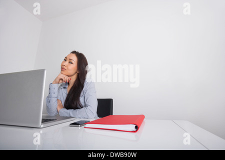 Thoughtful businesswoman sitting at office desk Banque D'Images