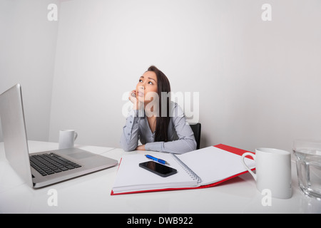 Thoughtful businesswoman sitting at desk in office Banque D'Images