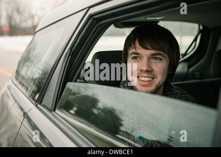 Jeune homme à la fenêtre de la voiture de Banque D'Images