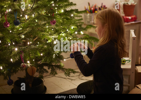 Young Girl decorating Christmas Tree Banque D'Images