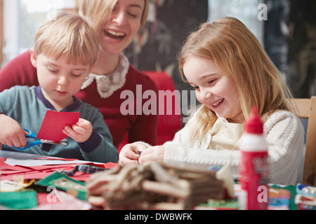 La mère et deux enfants à l'élaboration de la table de cuisine Banque D'Images