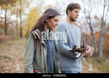 Couple avec bois de chauffage en forêt Banque D'Images