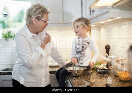 Grand-mère et petite-fille de préparer un repas dans la cuisine Banque D'Images