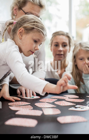 Girl jeu de carte jeu de puzzle avec la famille à la maison Banque D'Images