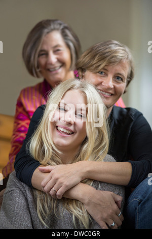 Portrait de trois générations de femmes assis dans une rangée à la maison Banque D'Images