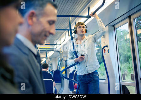 Jeune homme du train listening to headphones Banque D'Images