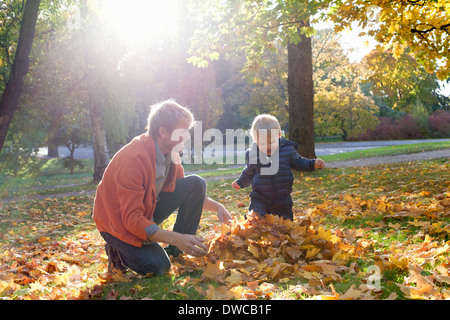 Père et fils en jouant avec les feuilles d'automne Banque D'Images