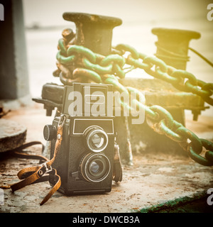 Vintage camera près d'une borne d'amarrage à quai, stylisé rétro Banque D'Images