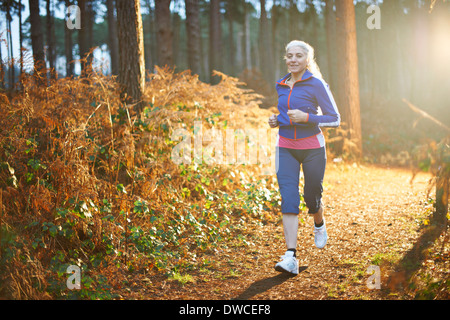 Young woman jogging le chemin forestier Banque D'Images