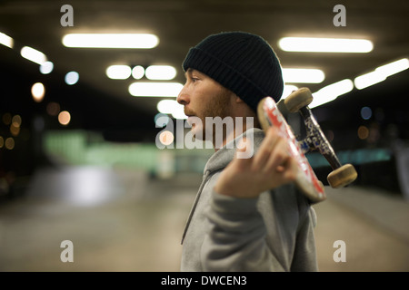 Portrait of young man holding skateboard Banque D'Images