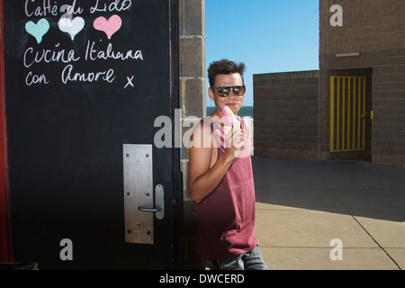Jeune homme à l'extérieur tout en étant lolly glaces Banque D'Images