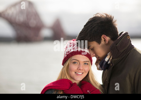 Un jeune couple posent devant le pont Forth Rail en Queensferry, près d'Édimbourg, Écosse Banque D'Images