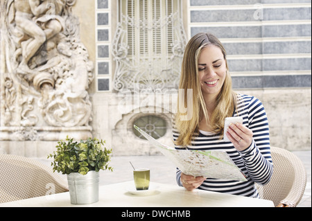 Young woman looking at smartphone à l'extérieur Musée de la céramique, Valencia, Espagne Banque D'Images