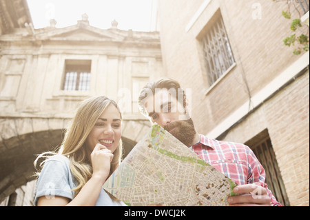 Jeune couple de touristes à la carte à l'extérieur de la cathédrale de Valence, Valence, Espagne