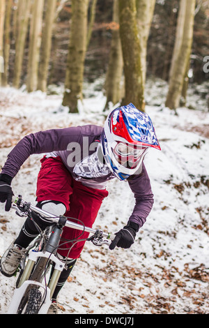 Jeune femme vélo de montagne équitation descente à travers la forêt Banque D'Images