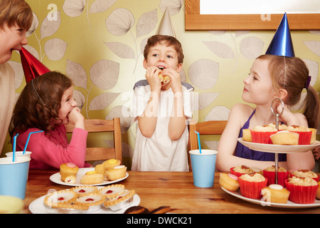 Les enfants de manger des aliments parti at Birthday party Banque D'Images