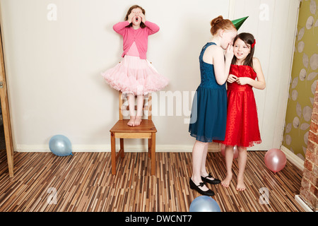 Trois jeunes filles, jouant à cache-cache at Birthday party Banque D'Images